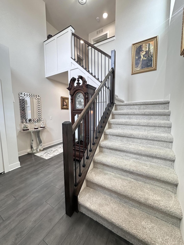 stairs featuring visible vents, baseboards, and wood finished floors