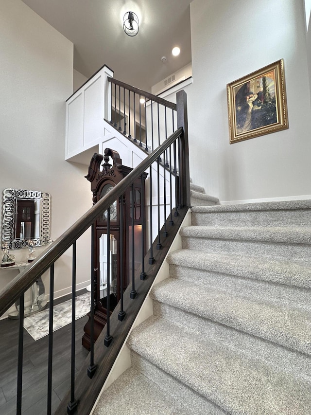 stairs with visible vents, baseboards, and wood finished floors