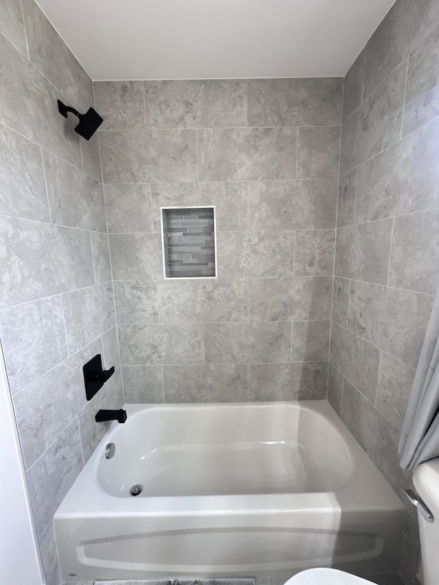 bathroom with tub / shower combination and toilet