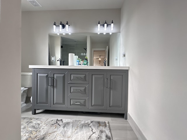 full bath featuring toilet, visible vents, baseboards, double vanity, and a shower with door