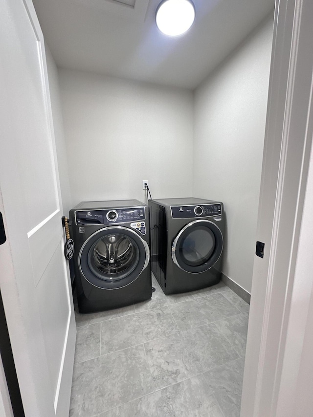 laundry area with laundry area, baseboards, and separate washer and dryer