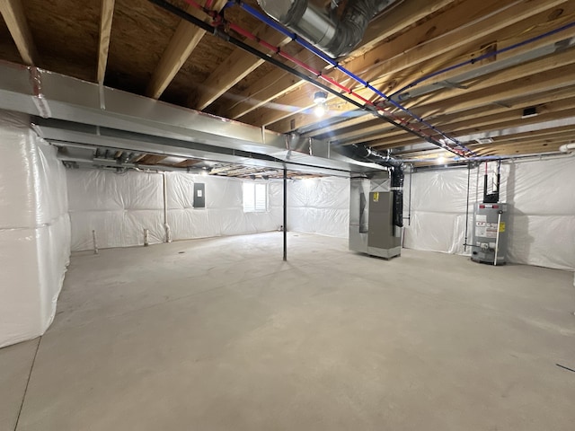 basement with gas water heater, electric panel, and heating unit