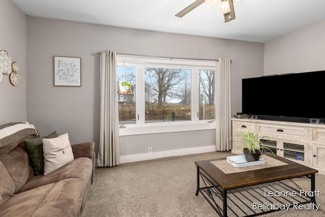 living area featuring carpet, ceiling fan, and baseboards