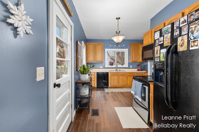 kitchen with dark wood-style floors, light countertops, visible vents, a sink, and black appliances