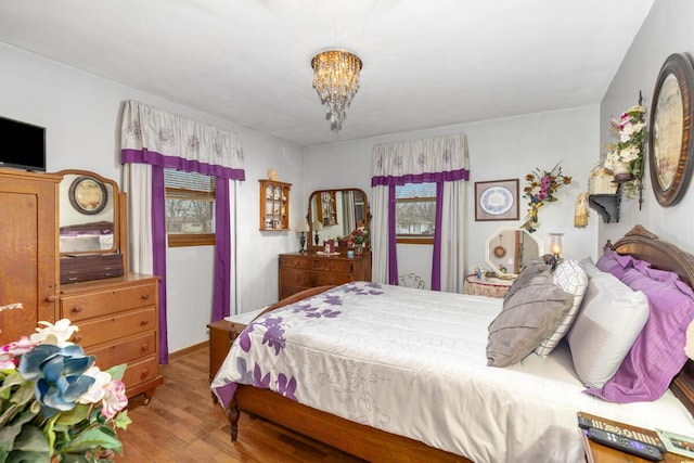 bedroom featuring a notable chandelier and wood finished floors