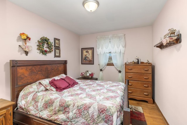 bedroom with light wood finished floors and baseboards