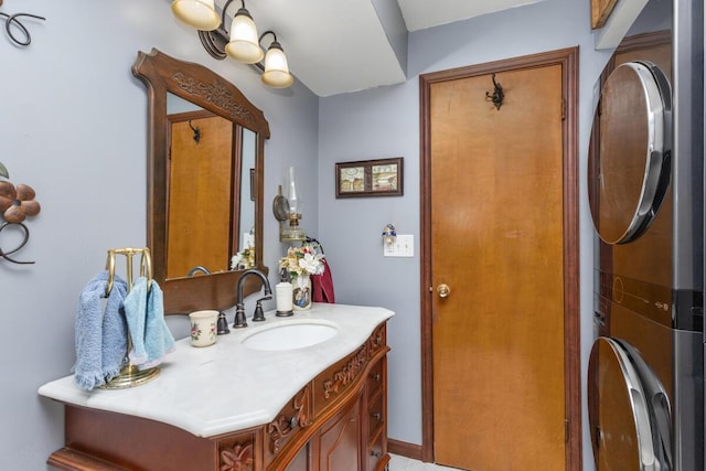 bathroom featuring stacked washer and dryer and vanity