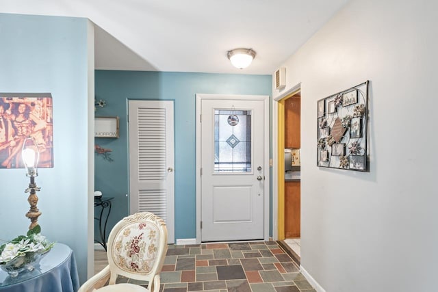 entryway featuring stone finish floor, visible vents, and baseboards