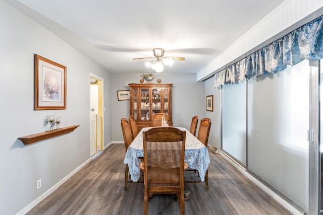 dining space with ceiling fan, baseboards, and dark wood-style flooring