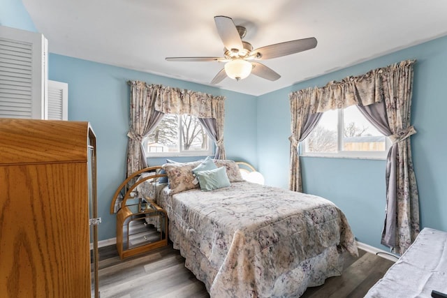 bedroom with ceiling fan, baseboards, and wood finished floors