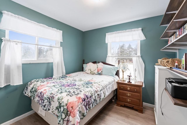 bedroom with baseboards and wood finished floors