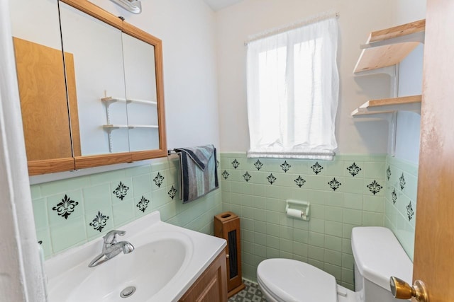 half bath featuring toilet, a wainscoted wall, and vanity