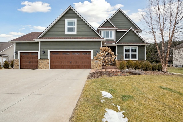 craftsman-style home with a garage, concrete driveway, stone siding, and a front lawn