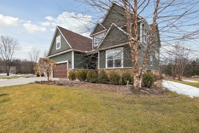 view of front of home featuring stone siding, concrete driveway, a front lawn, and a garage