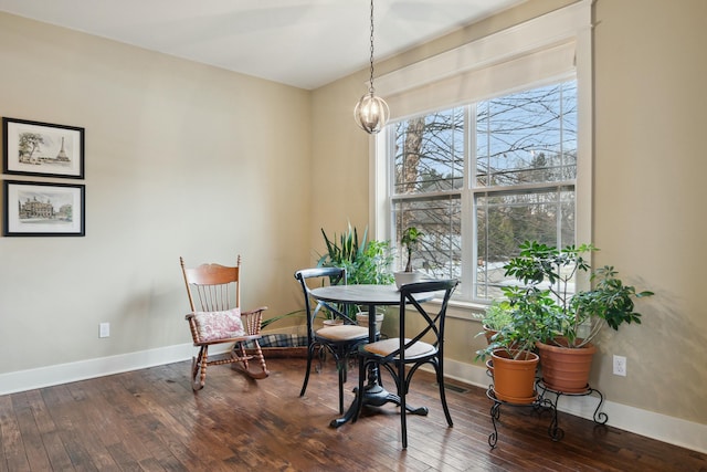 dining area featuring a chandelier, baseboards, and hardwood / wood-style flooring