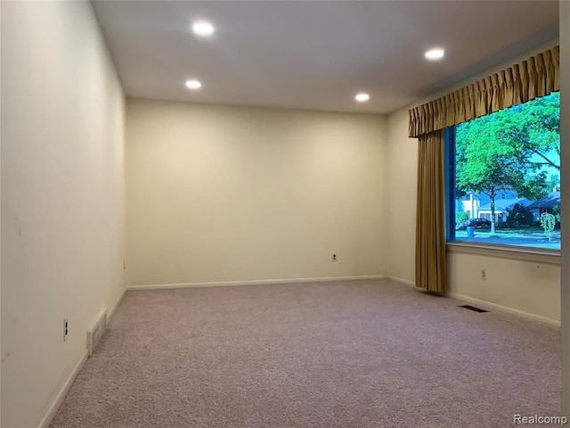 unfurnished room with recessed lighting, visible vents, light carpet, and baseboards