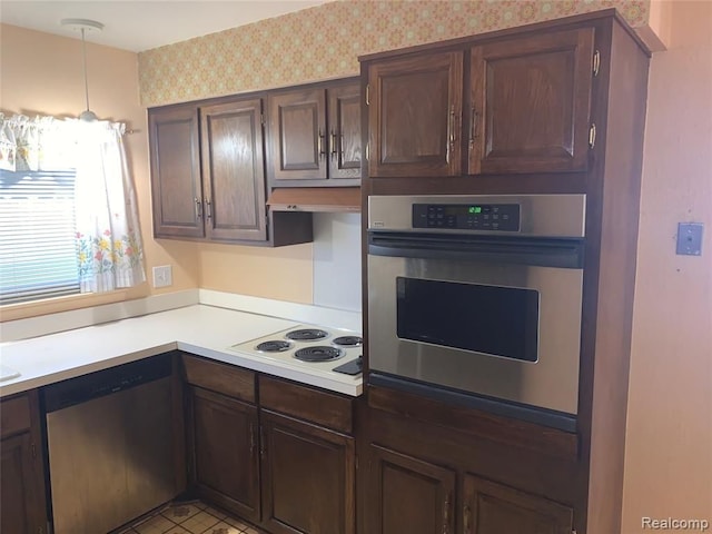 kitchen featuring dark brown cabinets, appliances with stainless steel finishes, light countertops, and wallpapered walls