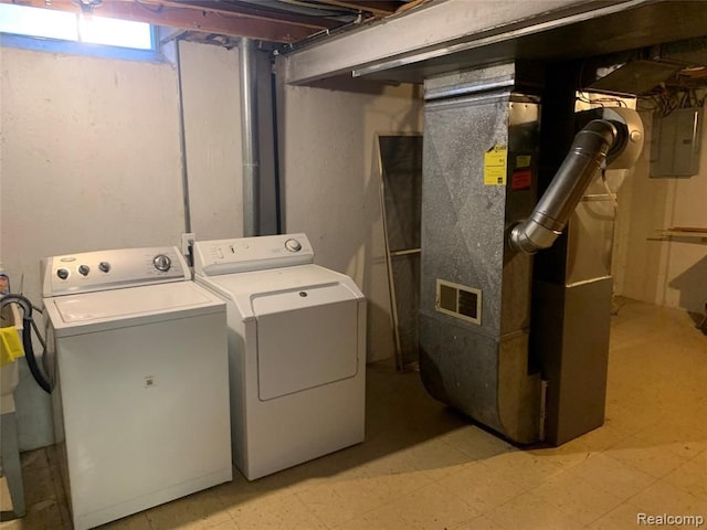 washroom featuring heating unit, light floors, separate washer and dryer, laundry area, and electric panel