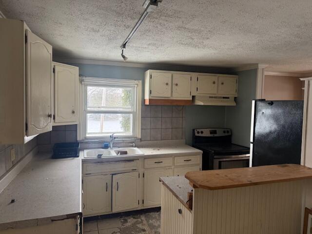 kitchen featuring electric range, decorative backsplash, freestanding refrigerator, under cabinet range hood, and a sink