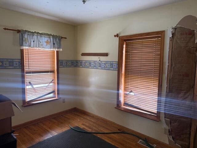 spare room with wood finished floors and baseboards