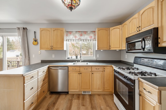 kitchen featuring stainless steel dishwasher, light brown cabinetry, a sink, white range with gas cooktop, and black microwave