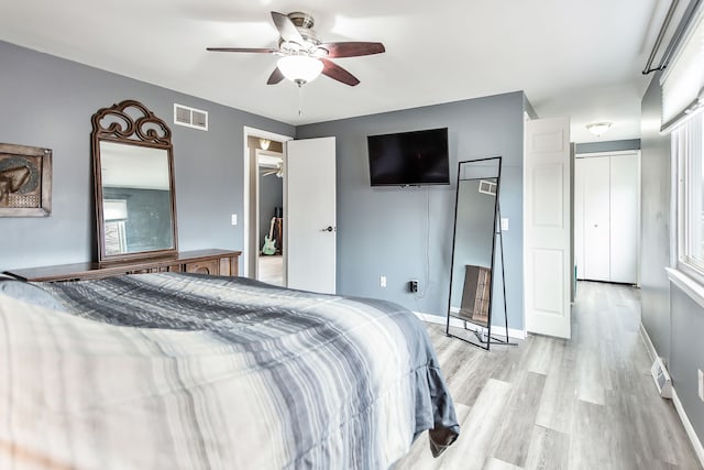 bedroom featuring light wood-type flooring, baseboards, visible vents, and ceiling fan