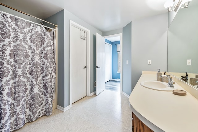 full bathroom with a shower with shower curtain, vanity, and baseboards