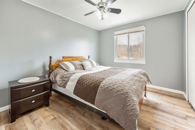 bedroom featuring ceiling fan, baseboards, and wood finished floors