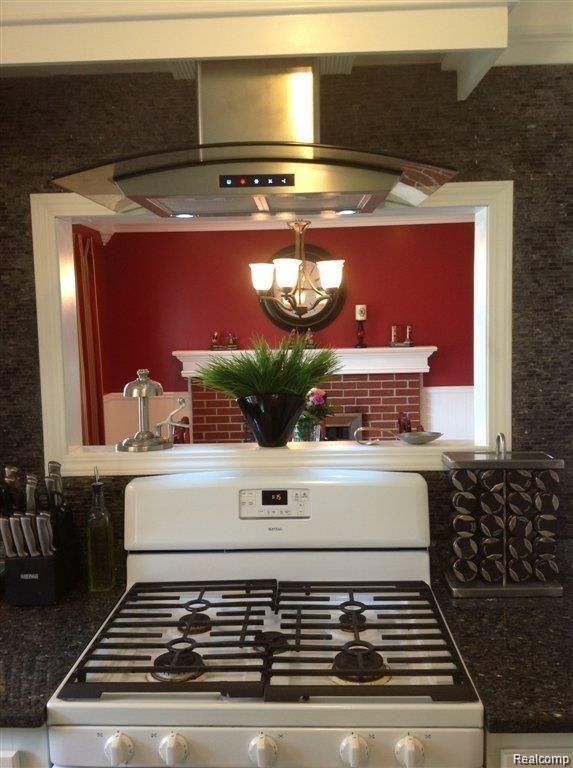 kitchen with wall chimney range hood and gas range gas stove