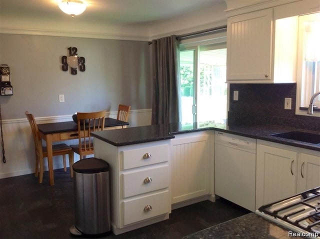 kitchen featuring cooktop, white cabinets, dishwasher, a peninsula, and a sink