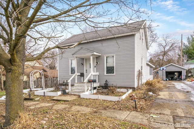 view of front of house featuring a garage and an outbuilding