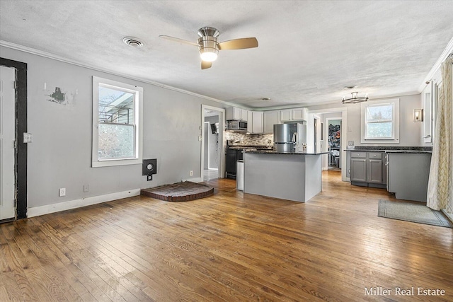 kitchen featuring appliances with stainless steel finishes, hardwood / wood-style flooring, visible vents, and gray cabinetry