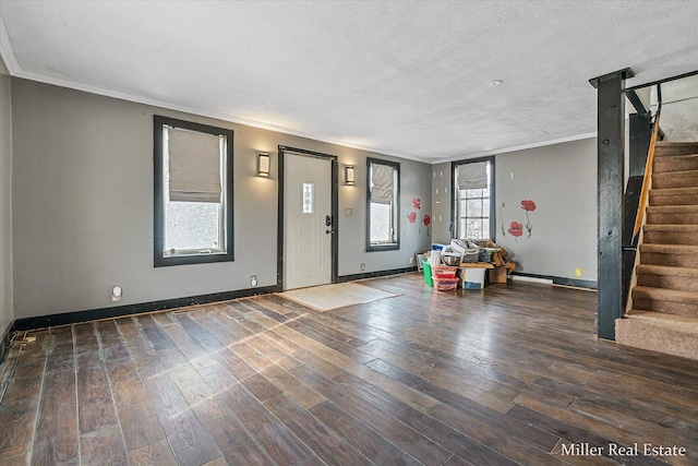 entryway with baseboards, wood-type flooring, ornamental molding, stairs, and a textured ceiling