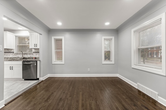 kitchen featuring stone countertops, dark wood-type flooring, visible vents, white cabinetry, and dishwasher