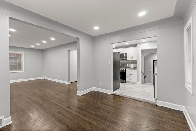 unfurnished living room with dark wood-style floors, recessed lighting, visible vents, and baseboards