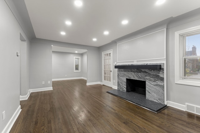 unfurnished living room featuring a fireplace, recessed lighting, visible vents, wood finished floors, and baseboards