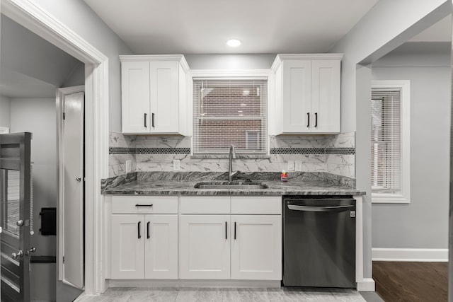 kitchen with dishwasher, dark stone counters, a sink, and white cabinets