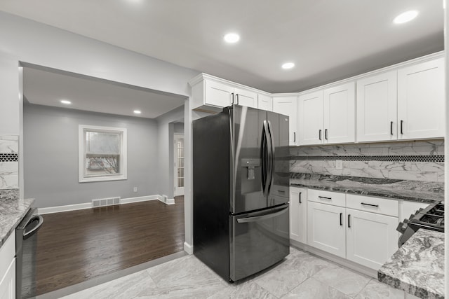 kitchen with stainless steel refrigerator with ice dispenser, white cabinetry, dark stone countertops, gas range, and dishwasher