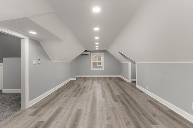 bonus room with baseboards, wood finished floors, vaulted ceiling, a wall mounted AC, and recessed lighting