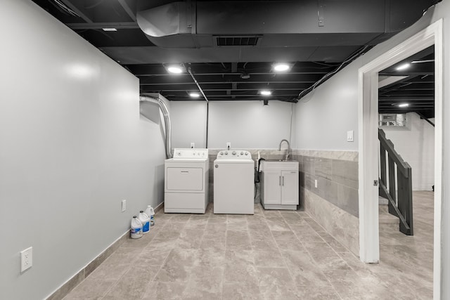 laundry room with cabinet space, independent washer and dryer, visible vents, and a sink