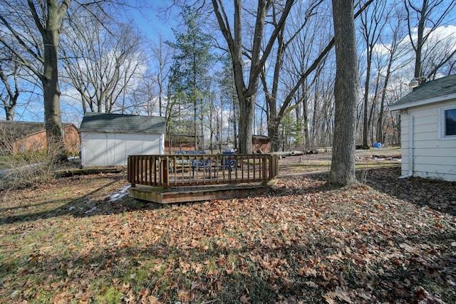 view of yard with a wooden deck, a storage unit, and an outdoor structure