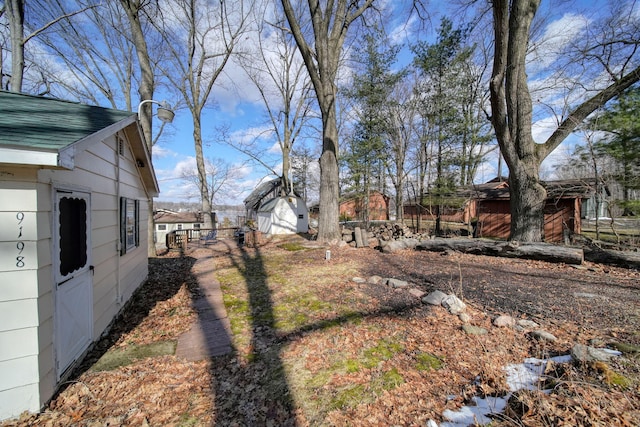 view of yard with an outbuilding, a storage unit, and fence