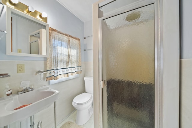 bathroom featuring a sink, a shower stall, and toilet