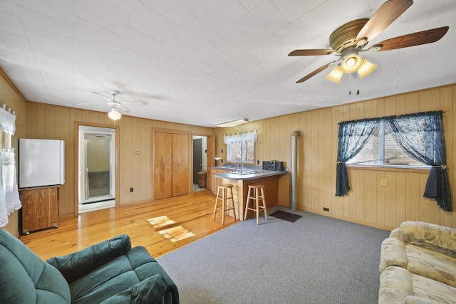 living area with light carpet and a ceiling fan