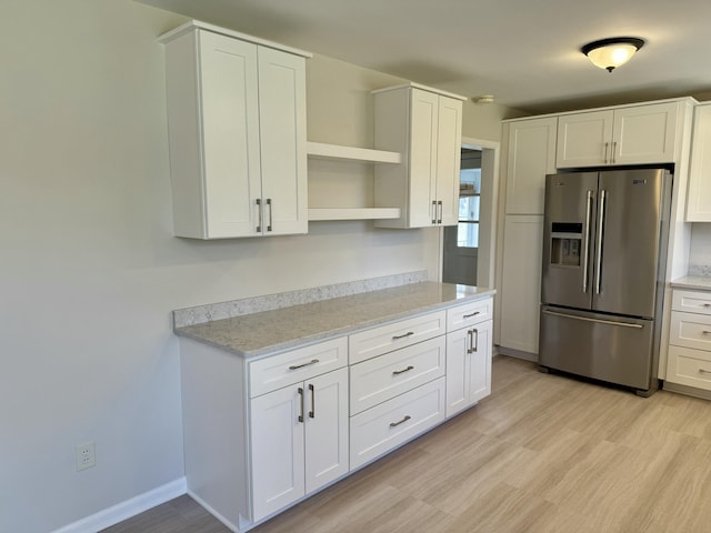 kitchen featuring open shelves, light wood-style floors, white cabinets, and stainless steel fridge with ice dispenser