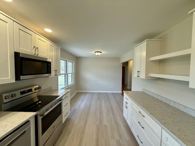 kitchen featuring light wood finished floors, open shelves, appliances with stainless steel finishes, white cabinetry, and baseboards