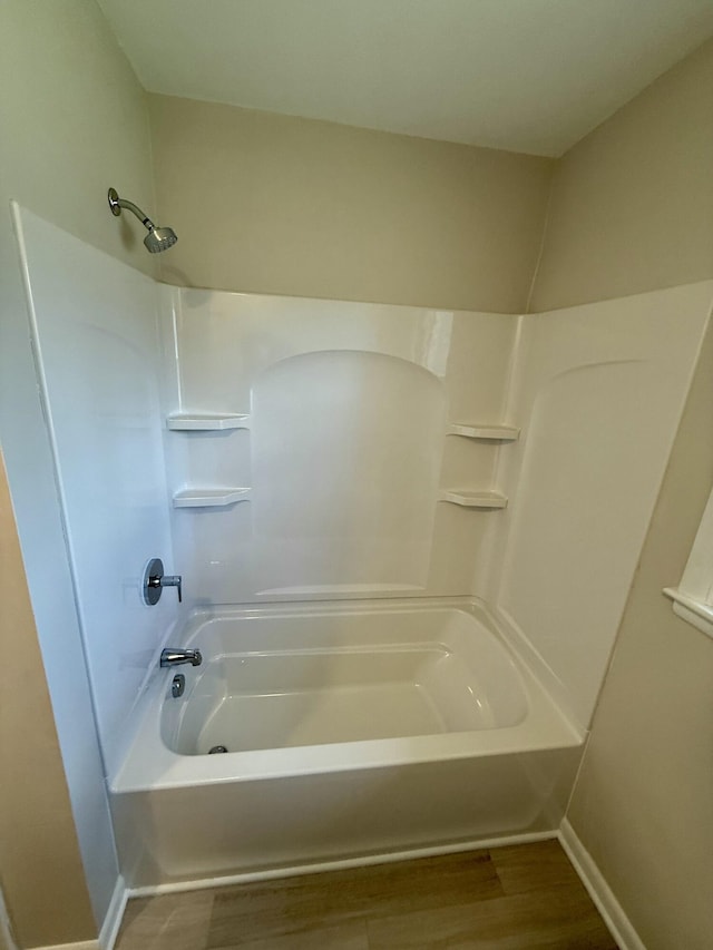 bathroom featuring shower / bath combination, baseboards, and wood finished floors