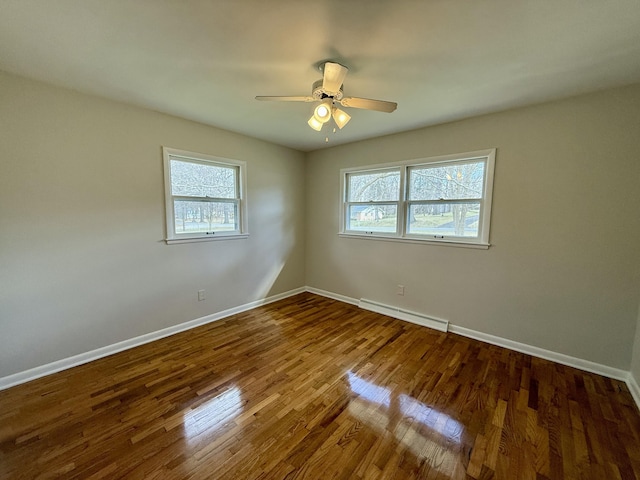 unfurnished room featuring a ceiling fan, baseboards, baseboard heating, and wood finished floors