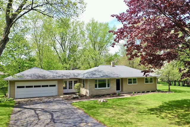 ranch-style house with driveway, a garage, a front yard, and a chimney