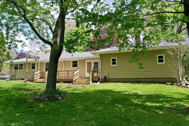 rear view of property featuring a deck and a lawn